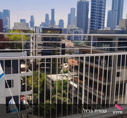 נוף עירוני עם מרפסת וסורגים ודגלי ישראל
